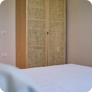 Wooden wardrobe near bed